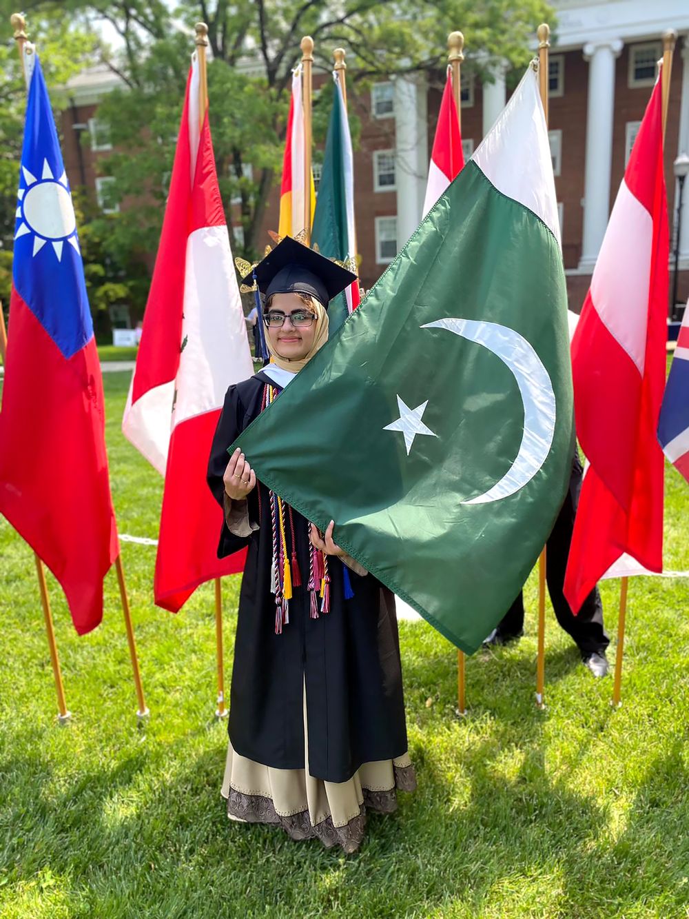 Maryam at graduation holding the Pakistani flag